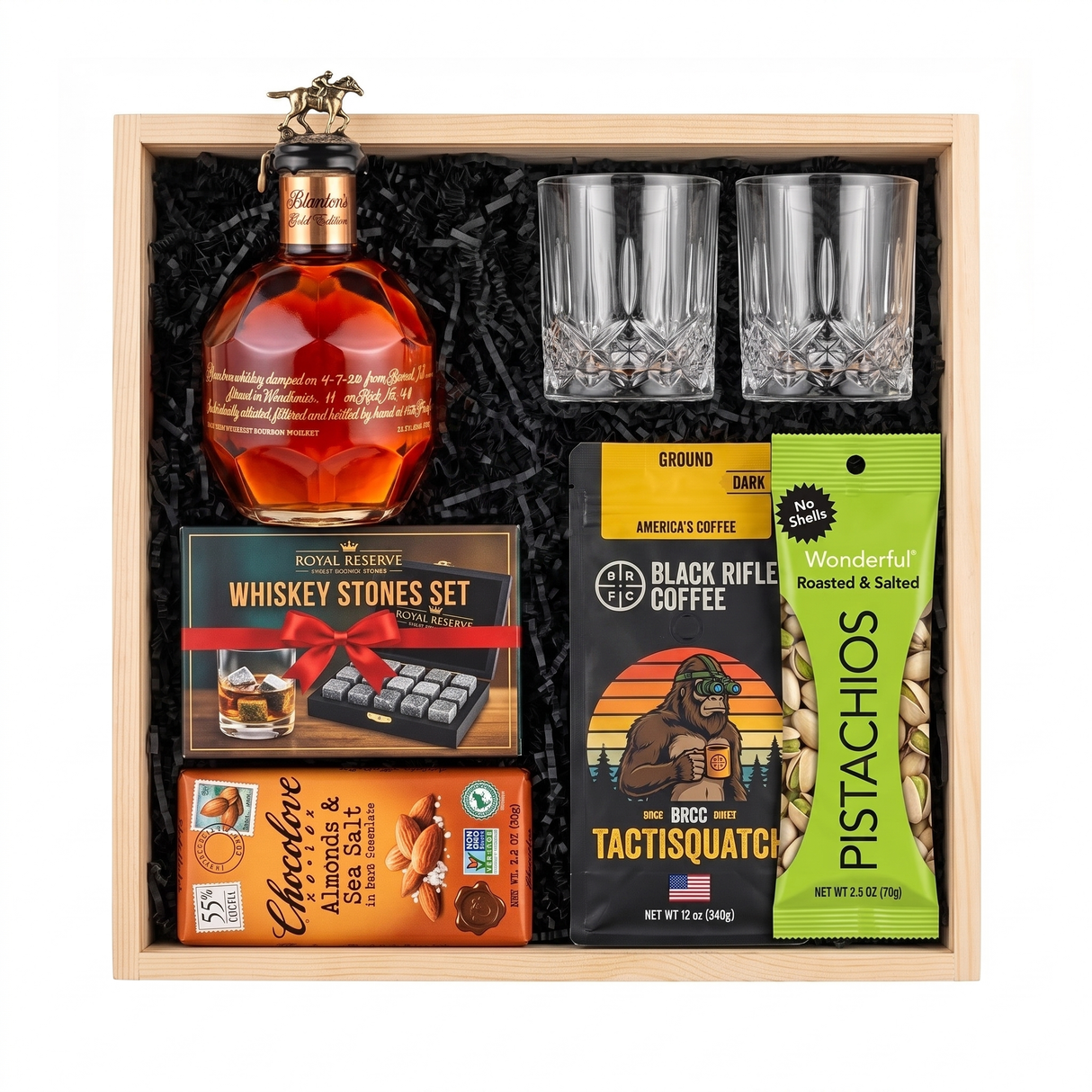 Blanton's Gold Edition bourbon gift crate with two crystal-cut glasses, whiskey stones, ground coffee, dark chocolate, and pistachios nested in a natural wood crate.