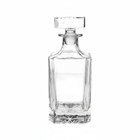 Clear glass decanter on a beige background