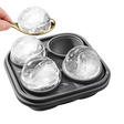 Whiskey ice molds tray with spoon and large round ice spheres on white background