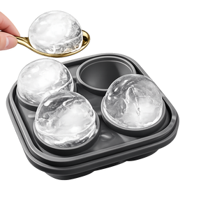 Whiskey ice molds tray with spoon and large round ice spheres on white background