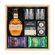 Blanton's Original Single Barrel Bourbon gift crate with iconic horse stopper, crystal-cut old fashioned glasses, premium whiskey stones gift set, XXL stainless steel whiskey balls with freezer tray, Ghirardelli Dark Chocolate Lava Cake, and Ghirardelli Milk Chocolate Mint Cookie in black crinkle paper on white background