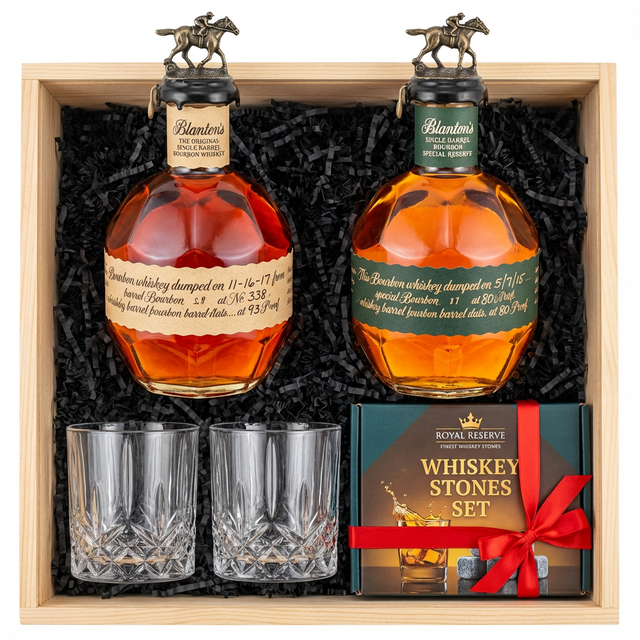 Blanton's Original Single Barrel Bourbon 750ml and Blanton's Special Reserve Green Label 700ml dual-bottle gift crate with bronze horse stoppers, crystal-cut old fashioned glasses with vertical ribs and starburst base, and Royal Reserve whiskey stones gift box with red ribbon all nestled in black crinkle paper inside wooden crate on white background