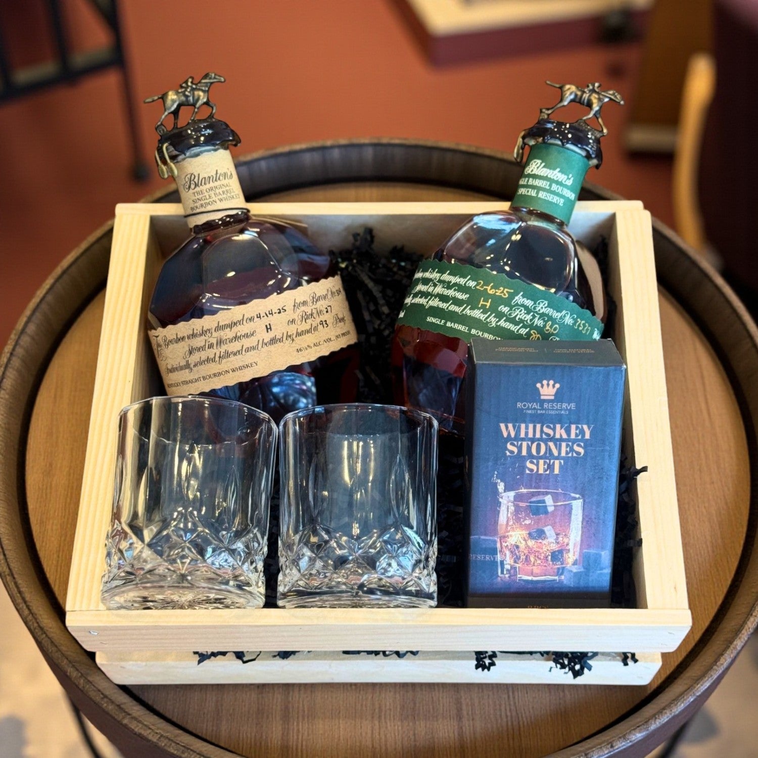 Blanton’s Original and Special Reserve Bourbon Gift Crate with crystal cut glasses and whiskey stones set on a barrel – lifestyle shot from Total Bourbon