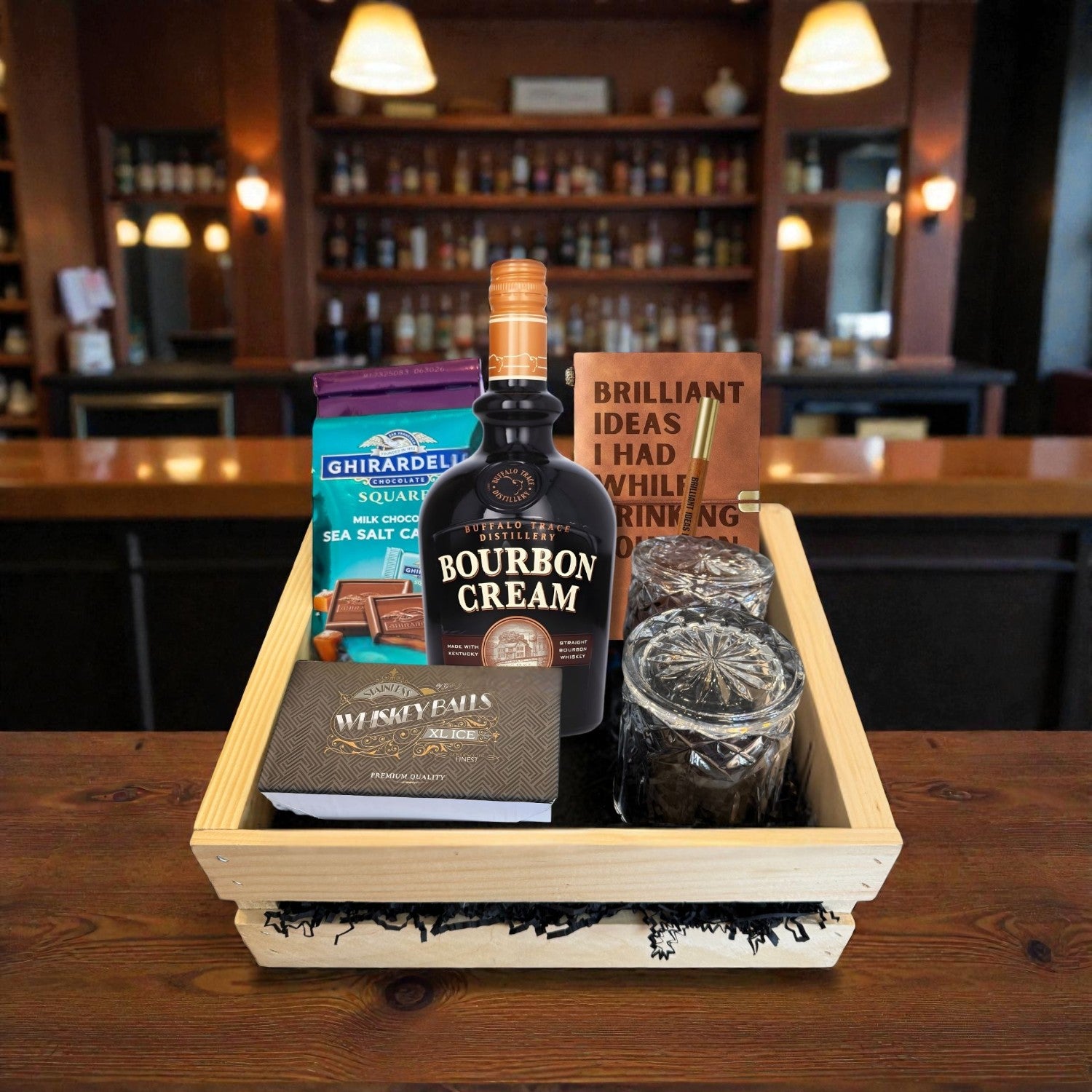 Buffalo Trace Bourbon Cream Gift Crate displayed on a bar top with chocolate, whiskey balls, engraved glasses, and journal – premium bourbon liqueur gift set