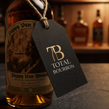 Bottle of Pappy Van Winkle bourbon with a Total Bourbon tag in front of blurred bourbon bottles.