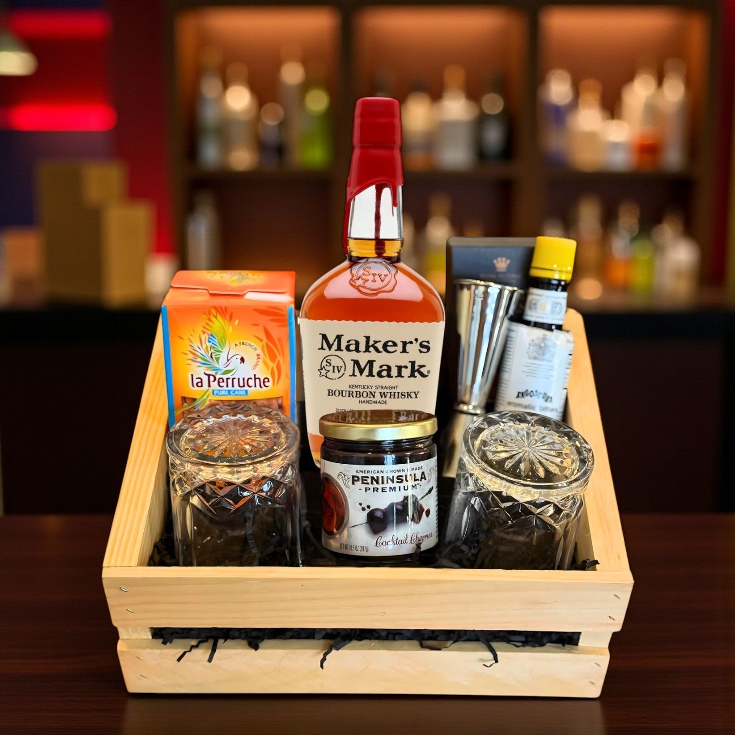 Maker’s Mark Old Fashioned Gift Crate with bourbon, bitters, sugar cubes, cherries, and engravable glasses on bar table – lifestyle photo from Total Bourbon