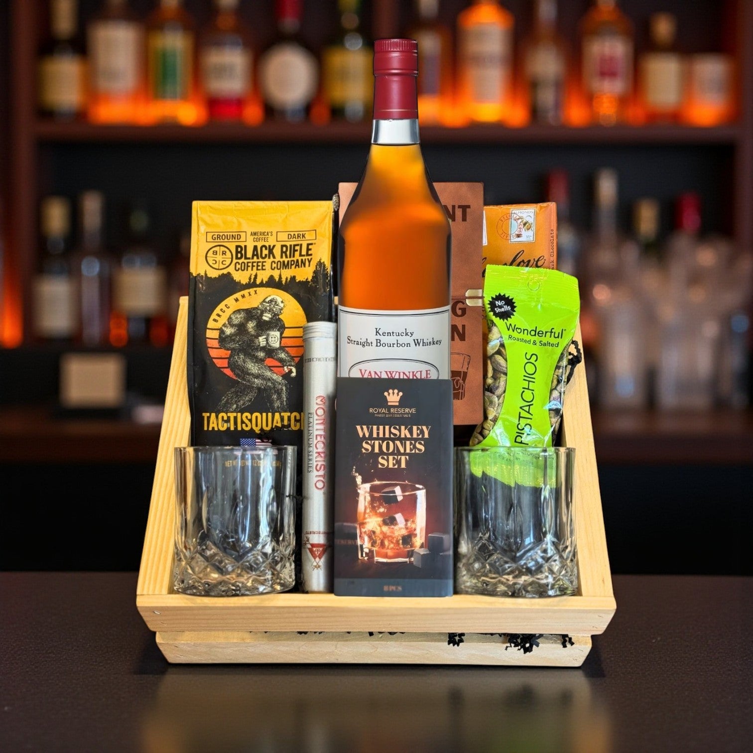 Pappy Van Winkle 12 Year Lot B Top Shelf Gift Crate with bourbon, glasses, journal, coffee, chocolate, pistachios, and cigar displayed in a wooden crate against a bar background – premium bourbon gift from Total Bourbon